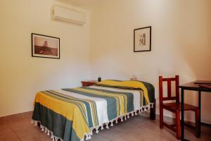 ein Schlafzimmer mit einem Bett, einem Tisch und einem Stuhl in der Unterkunft Casa Triz in Puerto Escondido