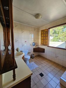 a bathroom with a toilet and a tub and a sink at Hostal el Parron in Rancagua
