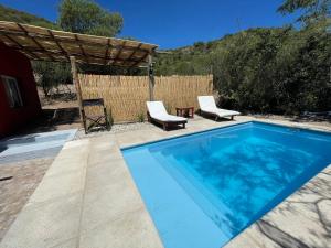 una piscina con 2 sillas y una mesa en Los 4 elementos en San Marcos Sierras