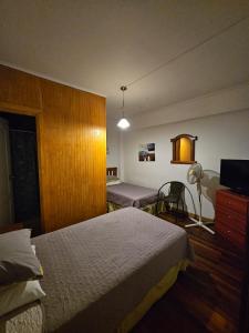 Habitación de hotel con 2 camas y TV en Hostal el Parron, en Rancagua