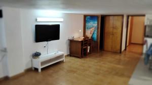 sala de estar con TV de pantalla plana en la pared en Amplio apartamento recién reformado en Tejina