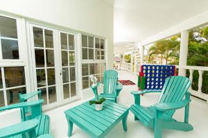 two blue chairs and a table on a porch at Villa Dance - Home with Steps to the Beach in Cabarete