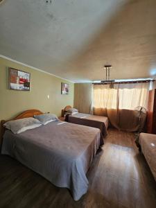 1 dormitorio grande con 2 camas y ventana en Hostal el Parron, en Rancagua