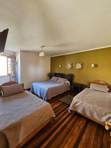 una habitación de hotel con 2 camas en una habitación en Hostal el Parron, en Rancagua