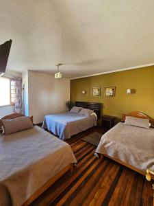 a hotel room with two beds in a room at Hostal el Parron in Rancagua