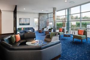 a lobby with couches and chairs and windows at Courtyard by Marriott San Jose North/ Silicon Valley in San Jose