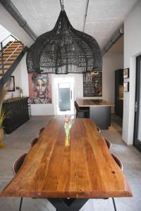 una mesa de madera con un jarrón de flores encima en Beautiful Design 2 BR Loft, en Mertert