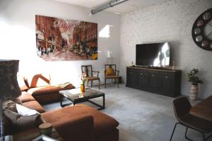 sala de estar con sofá y TV de pantalla plana en Beautiful Design 2 BR Loft, en Mertert