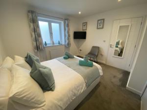 a bedroom with a bed with a chair and a window at Bed and breakfast near Truro and the A30 in Truro