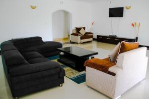 sala de estar con sofá y 2 sillas en Springfield Luxury Homes, en Kuywa