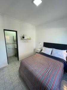 a bedroom with a large bed and a bathroom at Hermoso departamento panorámico en Rio Gallegos in Río Gallegos