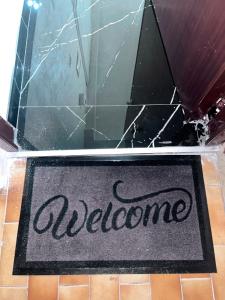 eine Willkommensmatte auf dem Boden eines Badezimmers in der Unterkunft Sweet Dreams luxury 3 in Neapel + 2 Fotos