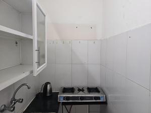 a small white kitchen with a stove in it at مدينة السلطان قابوس Sultan Qaboos city in Muscat