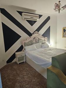 a bedroom with a white bed with black and white stripes at مدينة السلطان قابوس Sultan Qaboos city in Muscat