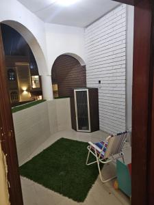 um quarto com uma cadeira e um tapete verde em مدينة السلطان قابوس Sultan Qaboos city em Mascate