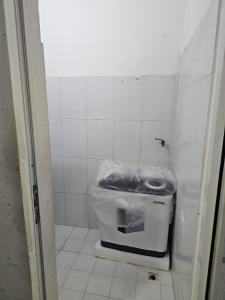 a small bathroom with a trash can in a stall at مدينة السلطان قابوس Sultan Qaboos city in Muscat