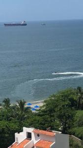 uma vista para uma praia com um barco na água em Exclusivo Sector 1 Cuadra Playa em Santa Marta
