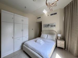 a bedroom with a bed with white cabinets and a chandelier at Luxury apartment 3 beds Marina view in Dubai +4 photos
