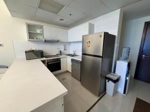 een keuken met een roestvrijstalen koelkast en een aanrecht bij Luxury apartment 3 beds Marina view in Dubai