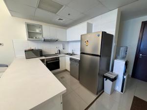 a kitchen with a stainless steel refrigerator and a counter at Luxury apartment 3 beds Marina view in Dubai