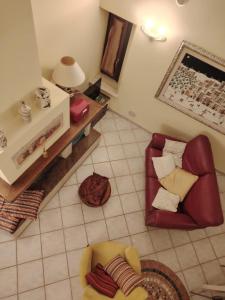 een woonkamer met een rode stoel en een bank bij LA CASA TRA GLI ULIVI in Spello