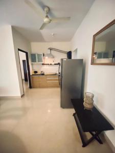 a kitchen with a refrigerator and a table in a room at Luxury apartment Blue lagoon in Goa
