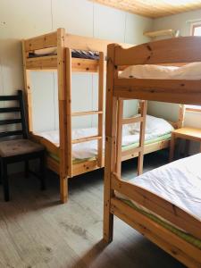 a room with three bunk beds and a chair at Rena Hostel in Rena