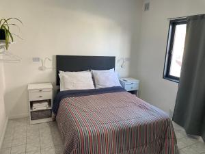 a bedroom with a bed with a striped comforter and a window at Hermoso departamento panorámico en Rio Gallegos in Río Gallegos