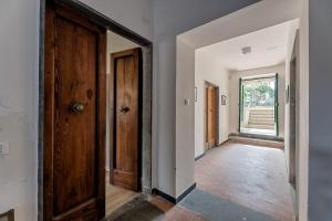 un couloir vide avec une porte et une fenêtre dans l'établissement Casa Balbi al Mare, giardino e posto auto privato, à Albisola Superiore