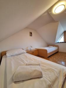 a attic bedroom with two beds and a window at Župnijski apartmaji in Dolenjske Toplice
