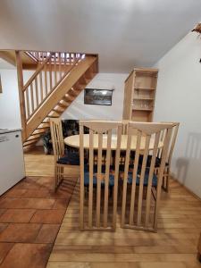 a kitchen with a table and chairs and a staircase at Župnijski apartmaji in Dolenjske Toplice