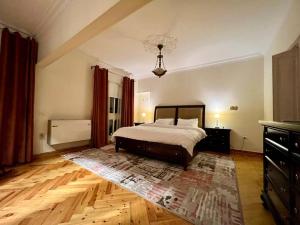 een slaapkamer met een bed en een houten vloer bij Delightful 3BR home in Zamalek (no visits) in Caïro