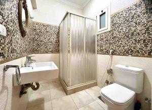 een badkamer met een toilet, een wastafel en een douche bij Delightful 3BR home in Zamalek (no visits) in Caïro
