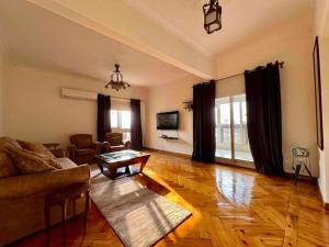 a living room with a couch and a table at Delightful 3BR home in Zamalek (no visits) in Cairo