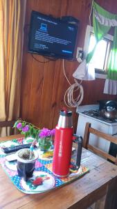 une table avec un thermos rouge au-dessus d'une table dans l'établissement Cabañas Aliwen, à Puerto Bossetti