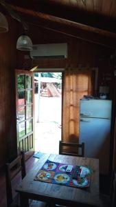 a kitchen with a table and a refrigerator at Cabañas Aliwen in Puerto Bossetti