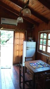 cocina con mesa de madera y nevera en Cabañas Aliwen en Puerto Bossetti