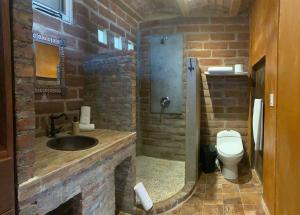 a brick bathroom with a sink and a toilet at Baja69 lodge in El Pescadero