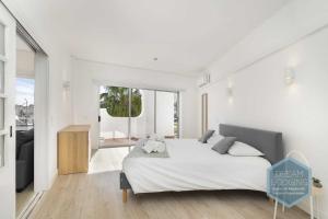 a white bedroom with a large bed with white sheets at Artens 407 Dream Lodging in Albufeira
