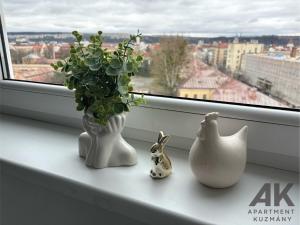 un alféizar con un jarrón con una planta y dos conejos en Apartment Kuzmany, en Košice