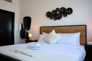 een slaapkamer met een bed met hoeden aan de muur bij Divine 1BR Apartment in Al Reef. in Yas Island