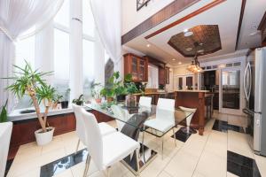 Luxurious 8-Bedroom Villa in Central Vancouver في فانكوفر: غرفة طعام مع طاولة زجاجية وكراسي بيضاء