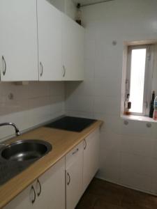 a kitchen with white cabinets and a sink and a window at Apartamento 3 Dormitorios en Sanchez Preciados in Madrid