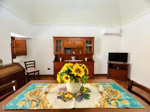 Una habitación con una mesa con un jarrón de flores. en Nonna Sasà, en Torretta