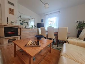 uma sala de estar com um tabuleiro de xadrez sobre uma mesa em Apartament Leśna z ogrodem em Szklarska Poręba