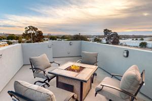 eine Terrasse mit einem Tisch und Stühlen auf dem Balkon in der Unterkunft The Luxe Overlook in Oceano