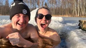 Un uomo e una donna in una vasca idromassaggio nella neve di Mini saunahouse 