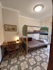 una camera con 2 letti a castello e una scrivania di Casa Laura a Lucca
