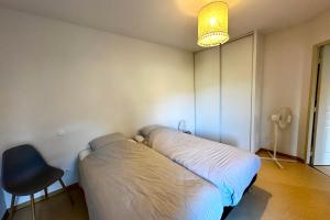 a bed in a room with a chair and a lamp at Les Naïades F27 - 1 bedroom for 4 people ! in Avène
