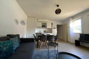 a living room with a couch and a table and chairs at Les Naïades C05- 2 bedrooms for 5 people ! in Avène